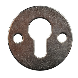 May include: A circular, silver-colored keyhole escutcheon with a keyhole-shaped opening in the center and two smaller holes on either side. The metal has a brushed texture.
