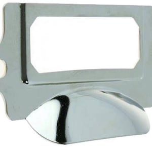 May include: Chrome-plated metal label holder with a rectangular label slot and a curved bottom. The holder has two holes on the sides for mounting.
