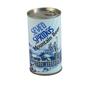 May include: Vintage Seven Springs Mountain Beer can. The can is cylindrical with a silver top and a pull tab. The label is light blue with the words "SEVEN SPRINGS Mountain Beer" in blue. A blue and white illustration of a mountain scene is also on the can.