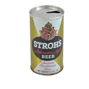 May include: Vintage Stroh's Bohemian Style Beer can. The can is cylindrical with a silver top and a gold and white label. The label features the Stroh's logo, a crest with a lion, and the text "STROHS Bohemian Style BEER". It contains 12 fl oz.
