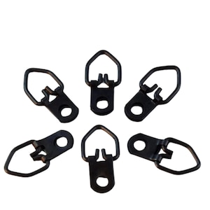 May include: Six black metal picture hanging hooks with a D-ring shape. The hooks have a pointed top and a flat back with a small hole for attaching to a picture frame.