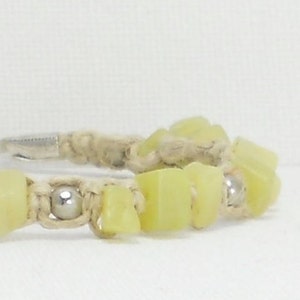 May include: A light green stone bracelet with silver beads and a hemp cord.