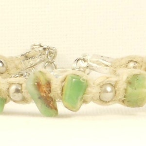 May include: A green and brown stone bracelet with silver clasps and white string.