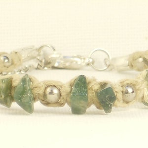 May include: A green agate stone bracelet with silver beads and a silver clasp. The bracelet is made with natural hemp cord.