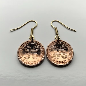 Op de afbeelding: Een paar gouden oorringen met koperen munt hangers. De munten zijn uit Finland en hebben de tekst "SUOMEN TASAVALTA 1963".