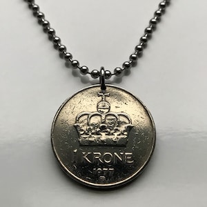 Puede incluir: Un collar de plata con un colgante de moneda de plata que presenta una corona y el texto "1 KRONA 1977".