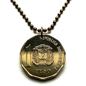 Könnte beinhalten: Eine goldfarbene Münzanhänger-Halskette. Die Münze trägt die Aufschriften „REPUBLICA DOMINICANA“ und „PESO“ mit einem Emblem. Die Halskette besteht aus kleinen, runden, bronzefarbenen Perlen.