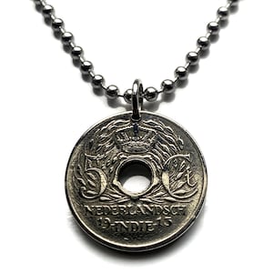 Op de afbeelding: Een zilverkleurige hangerketting met een vintage munt. De munt heeft een centraal gat en de tekst "NEDERLANDSCH 19-INDIE-15". De ketting is gemaakt van kleine, ronde, zilverkleurige kralen.