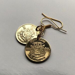 May include: Gold coin earrings featuring a Thai design with a gold hook. The coins have Thai text on them.