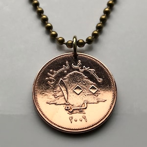 May include: A copper-colored pendant necklace featuring the Lebanese cedar tree and the Arabic text "Republic of Lebanon" on a brass chain.