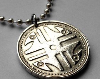 May include: Silver necklace with a round pendant featuring a geometric design and the word "JUMBA" inscribed on the edge.