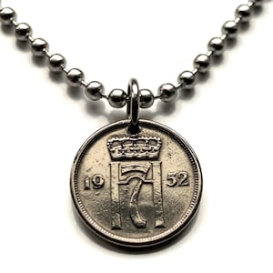 Puede incluir: Collar plateado con un colgante de moneda. La moneda muestra una corona sobre el número "17" y los años "19" y "52". El collar tiene un diseño de cadena de bolas, creando un accesorio simple pero elegante.