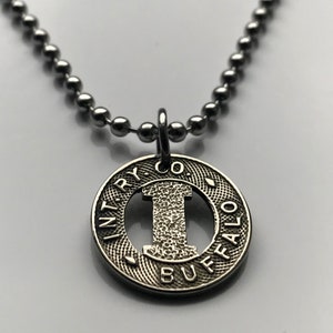 May include: Silver necklace with a round pendant featuring the text "INT'RY CO. BUFFALO" and a cutout of the letter "I".