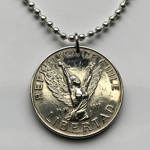 May include: Silver pendant necklace featuring a Chilean coin with the inscription "REPUBLICA DE CHILE" and "LIBERTAD" with a winged figure holding a torch.