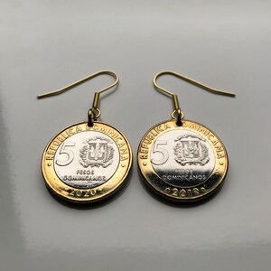 Könnte beinhalten: Ohrringe aus 5-Peso-Münzen der Dominikanischen Republik. Die Münzen haben einen goldenen Rand und eine silberne Mitte, mit einem goldfarbenen Haken. Eine Münze ist von 2020, die andere von 2019. Der Text 'Pesos Dominicanos' ist sichtbar.