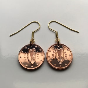 May include: A pair of gold earrings with copper Irish 1 cent coins featuring the harp and the year 2008. The coins are attached to gold hooks.