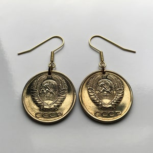 May include: Gold earrings with a round coin design featuring the Soviet Union's coat of arms and the inscription "CCCP".