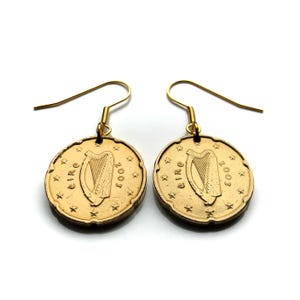 May include: Gold-colored earrings featuring a 2002 Irish Euro coin with the harp of Ireland on the front. The coin is attached to a gold-colored hook.