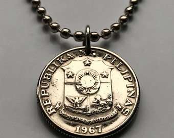 Pode incluir: Colar com pingente de moeda de prata. A moeda apresenta a inscrição "REPUBLIKA NG PILIPINAS" e o ano "1967". O pingente está preso a uma corrente de bolinhas de prata. A moeda tem um design detalhado com um sol, estrelas e uma águia.