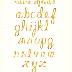 May include: A gold ribbon alphabet with each letter styled in a cursive font. The letters are arranged in three rows.