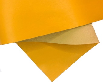 May include: Two pieces of yellow leather, one folded over the other. The leather has a smooth, slightly textured surface.