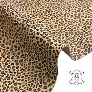 Könnte beinhalten: Ein Stück beiges Leder mit einem dunkelbraunen und schwarzen Leopardenmuster. Das Material ist gefaltet, um seine Textur und Dicke zu zeigen. Ein weißes Logo in der unteren rechten Ecke enthält den Text LEATHER AA ITALIAN LEATHER COMPANY.