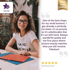May include: A woman wearing glasses and a white t-shirt with the text "LA VIE ST BELLE" smiles at the camera. The image includes a review badge, a "100% Real Leather" seal, and a customer quote.