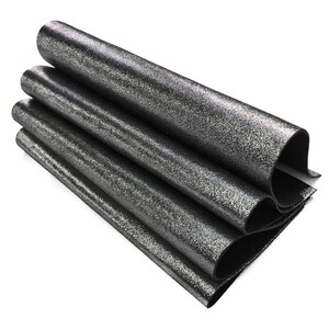 May include: A stack of rolled, dark gray material with a speckled, glittery finish. The material is folded over itself, revealing a black underside. The rolls are stacked on top of each other, creating a layered effect.