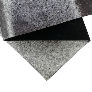 May include: Close-up of a folded piece of silver metallic fabric with a textured surface. The underside of the fabric is black. The fabric is on a white background.