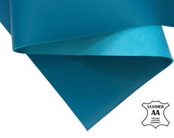 May include: Close-up of teal-colored leather sheets, layered to show the material's texture and color variation. The image includes the "Italian Leather Company" logo, indicating the origin and quality of the leather. The leather appears smooth and durable.