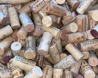 May include: A close-up of a pile of various wine corks. The corks are made of natural cork and have different labels and designs. Some of the labels include the names of vineyards, such as "Childress Vineyards", "Stone Mountain Vineyards", and "Rebec Vineyards".