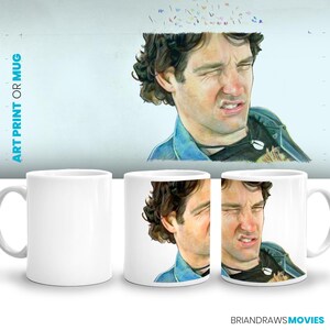 May include: White ceramic mug with a colorful illustration of a man with a disgusted expression. The man has brown hair and is wearing a blue denim jacket. The mug is a standard size and has a handle on the right side.