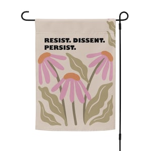 May include: A beige garden flag with a floral design and the text "Resist. Dissent. Persist."