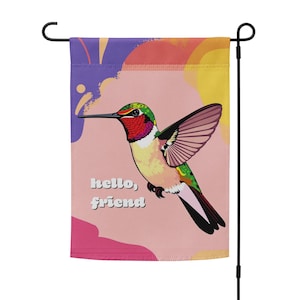 May include: A pink, yellow and purple garden flag with a colourful hummingbird illustration and the text "hello, friend".