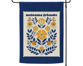 May include: A blue garden flag with a white border and a floral design in yellow and blue. The text "welcome friends" is printed in white on the flag.
