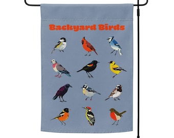 May include: A blue garden flag with the text "Backyard Birds" in orange. The flag features a variety of colorful birds, including a cardinal, a blue jay, a robin, and a woodpecker.