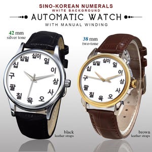 May include: Two automatic watches with Sino-Korean numerals on a white background. One watch is silver-toned, 42 mm, with a black leather strap. The other is two-tone, 38 mm, with a brown leather strap.