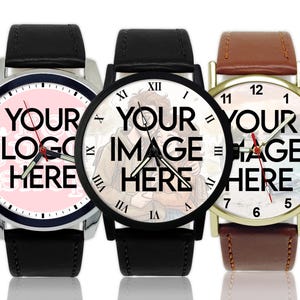 May include: Three custom watches with black leather straps. The watch faces display the text "YOUR LOGO HERE" and "YOUR IMAGE HERE". The watch on the right has a brown leather strap and a gold-coloured case.