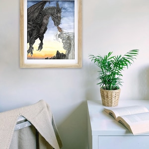 May include: A framed watercolor painting of a black dragon with a woman standing on a cliff. The dragon is flying towards the woman and appears to be breathing fire. The background is a sunset with mountains in the distance.