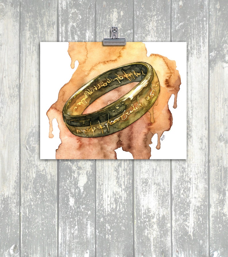 K&ouml;nnte beinhalten: Ein Aquarellbild eines goldenen Rings mit einer Inschrift in Schwarz. Der Ring befindet sich auf einem braunen und orangefarbenen Aquarellhintergrund.