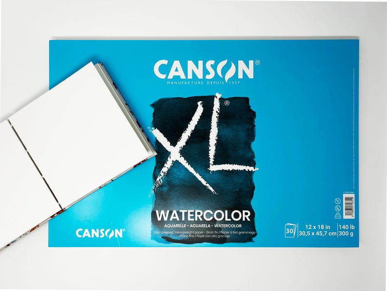 May include: A blue pad of Canson XL Watercolor paper. The pad is 12 by 18 inches and weighs 140 pounds. The paper is acid-free, cold-pressed, and has a smooth finish.