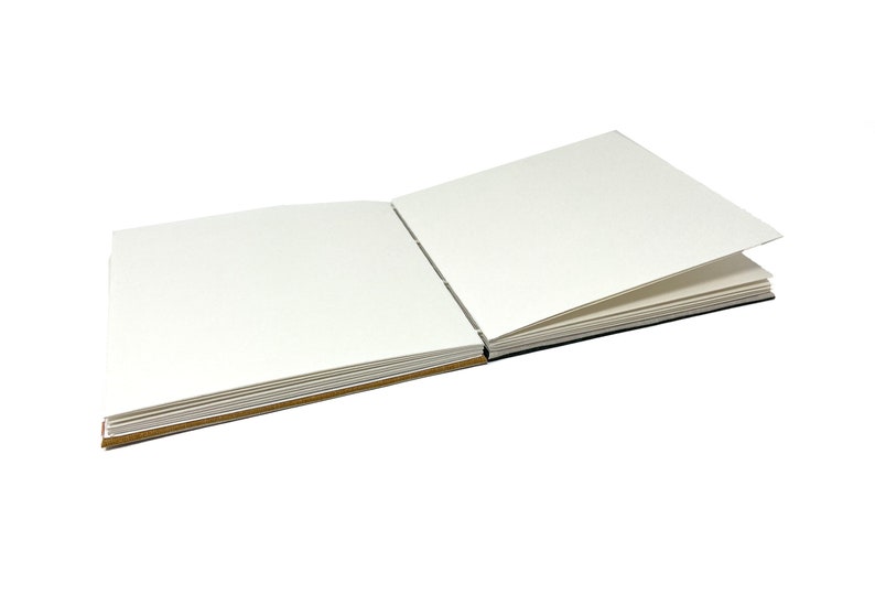 May include: A blank, white, square-shaped sketchbook with a brown spine and pages. The book is open to reveal the blank pages.