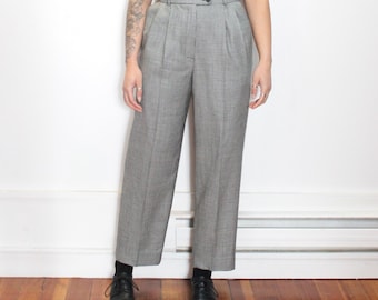 May include: Black and white houndstooth high-waisted pants with a wide leg. The pants have a classic tailored look and are made from a lightweight fabric.