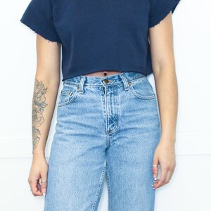 May include: A navy blue cropped sweatshirt with short sleeves and a relaxed fit.