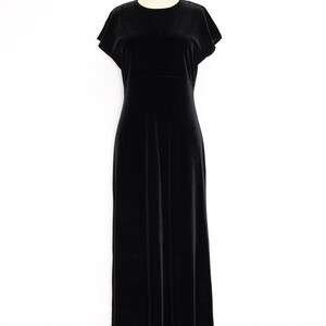 Puede incluir: Un vestido maxi de terciopelo negro con mangas cortas y cuello redondo. El vestido est&aacute; en un maniqu&iacute;.