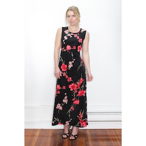 May include: A black maxi dress with a floral print featuring red and pink flowers. The dress has a sleeveless design and a scoop neck.