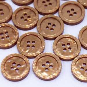 May include: A collection of 20 brown, four-hole buttons with a shiny, iridescent finish.