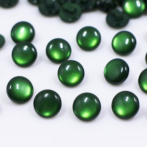 Peut inclure: Un ensemble de boutons en plastique vert. Les boutons sont ronds et ont une finition brillante.