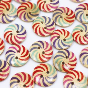 May include: A collection of colourful wooden buttons with a swirl design. The buttons are painted in shades of red, pink, purple, blue, and green.