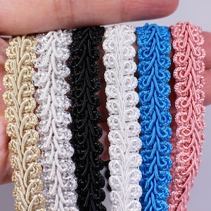 May include: Five different colors of decorative trim with a scalloped design. The colors are gold, white, black, white, blue, and pink.
